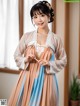 A woman in a blue and beige hanbok is posing for a picture.