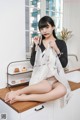 A woman sitting on top of a kitchen counter eating a piece of cake.