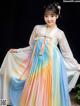 A young girl wearing a colorful hanbok is posing for a picture.