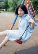 A woman sitting on a swing in a park.