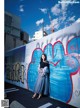 A woman standing in front of a wall covered in graffiti.