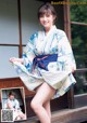 A woman in a blue and white kimono posing for a picture.