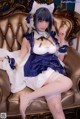 A woman in a maid outfit sitting on a couch.